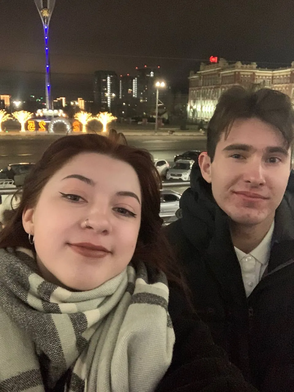 Пара делает совместный портрет на фоне ночных городских огней